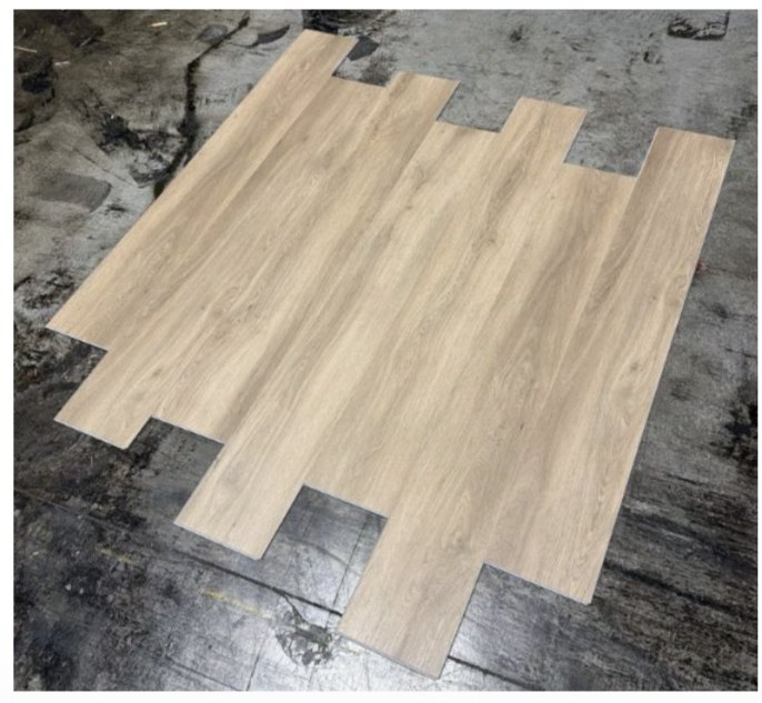 Blonde Oak waterproof LVP planks laid out and clicked together, showing the pale greige oak grain
